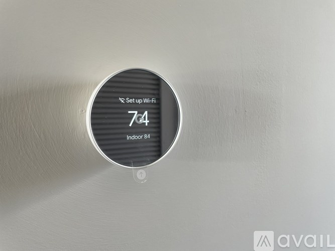 A round device mounted on a wall showing a Wi-Fi signal strength of 7/4.