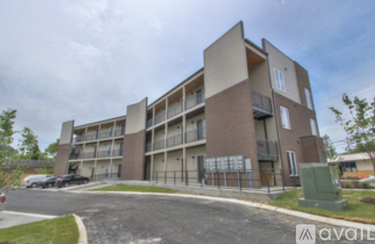 A large apartment building with a parking lot in front.