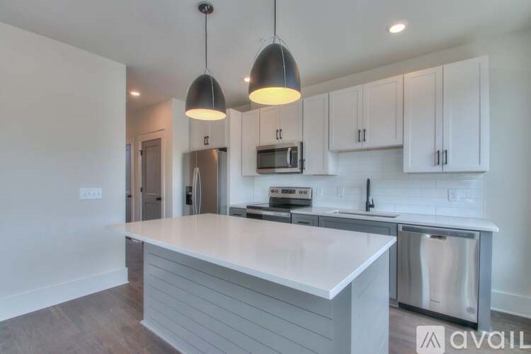 A kitchen with a white countertop and a stainless steel dishwasher.