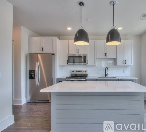 A modern kitchen with a white island and stainless steel appliances.