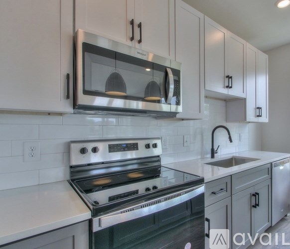 A modern kitchen with a stainless steel stove and microwave above it.