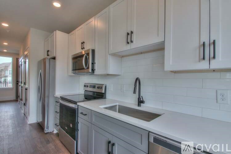 A kitchen with white cabinets and a white subway tile backsplash.