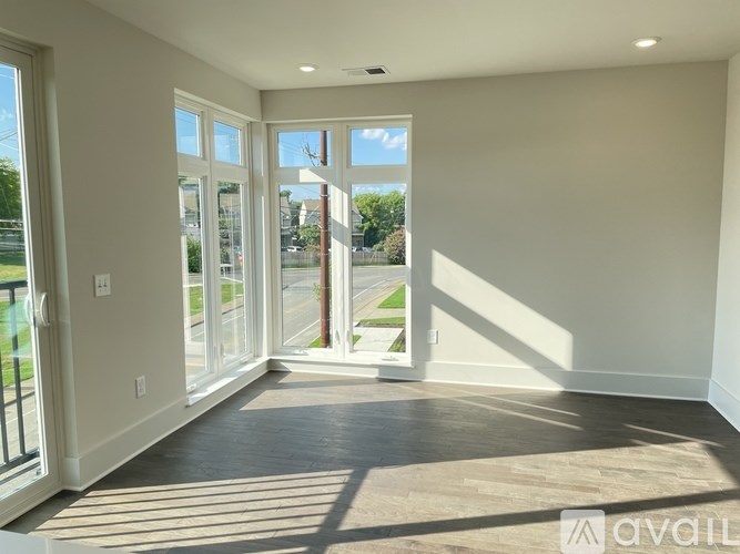 A room with a large window and sliding glass doors leading to a patio.