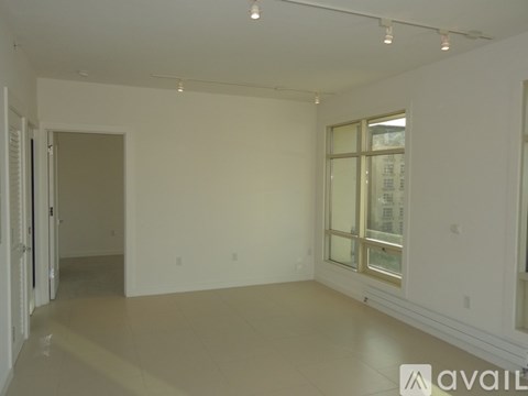 A spacious room with a doorway leading to another room.