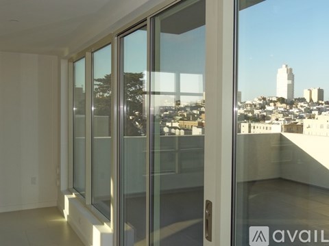 A room with a view of the city through large windows.