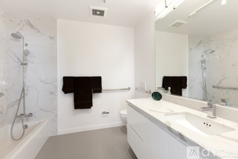 A bathroom with a marble wall and a white sink.