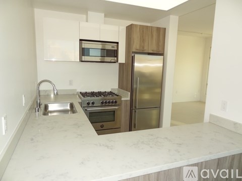 A kitchen with a marble countertop and stainless steel appliances.