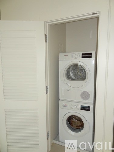A white washing machine is in a cabinet.