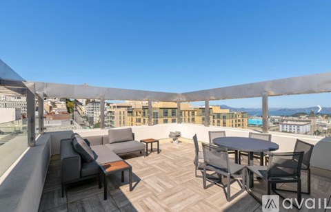 A patio with a table and chairs overlooking a cityscape.