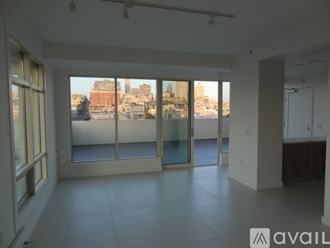 A spacious room with large windows overlooking a cityscape.