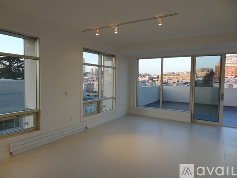 A large empty room with a view of the city through the windows.