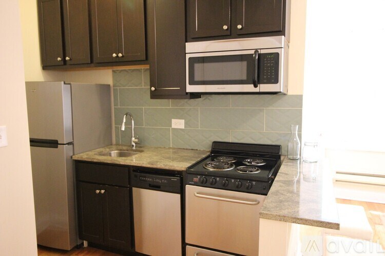 A kitchen with a black fridge and microwave, a black oven, and a black dishwasher.