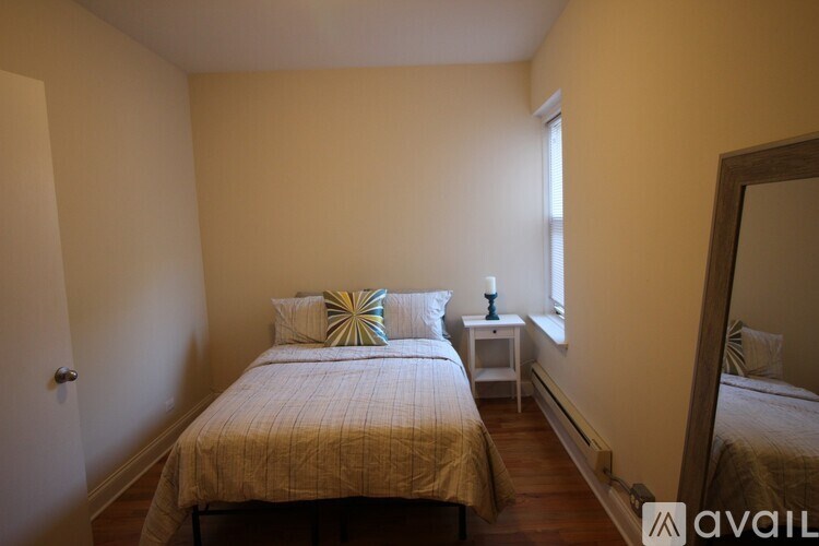 A bedroom with a bed, nightstand, and mirror.