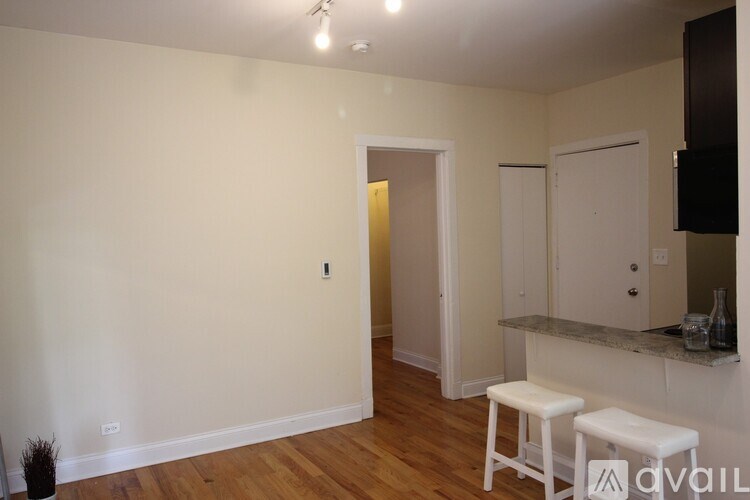 A room with a white chair and a counter with a plant on it.