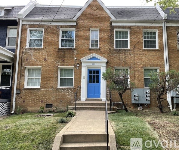 A brick house with a blue door and a sign that says "available".