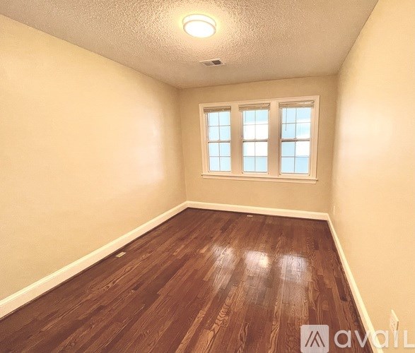 A room with wooden flooring and a window.