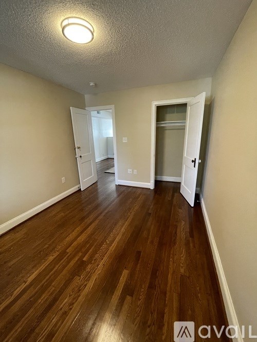 A room with wooden floors and two open doors.