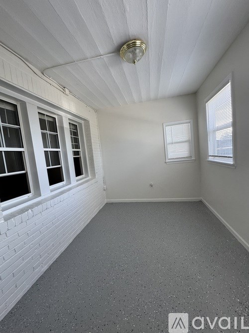 A room with white walls and a grey floor with a logo that says "AVAIL".