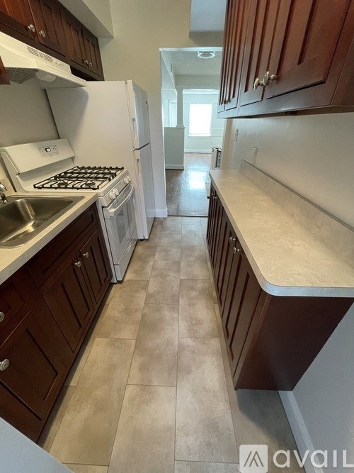 A kitchen with white appliances and brown cabinets.