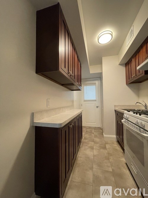 A kitchen with brown cabinets and a stainless steel stove.