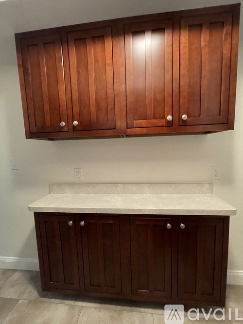 Brown cabinets with white countertops.
