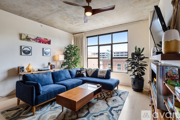 A living room with a blue sofa and a wooden coffee table.