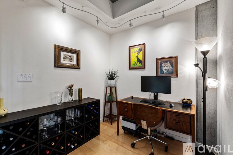 A room with a desk, chair, and a wine rack.