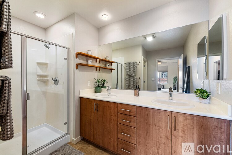 A bathroom with a wooden vanity and a walk-in shower.