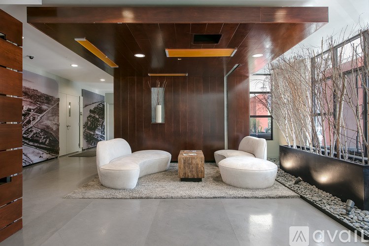 A modern living room with white furniture and a wooden accent wall.