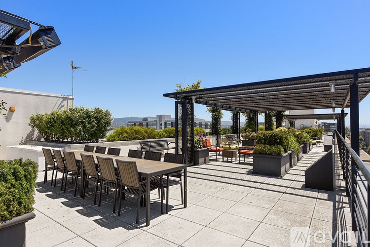 A patio with a table and chairs under a roof.