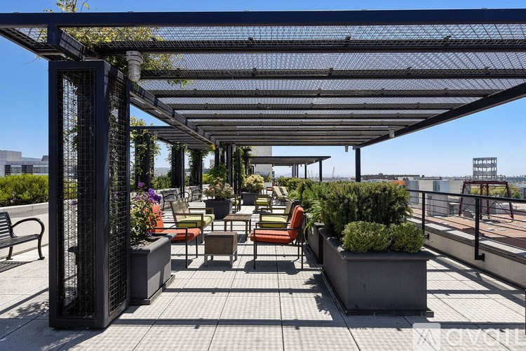 A patio with a metal roof and several chairs and tables.