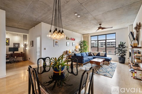 A modern living room with a black glass table and a blue sofa.