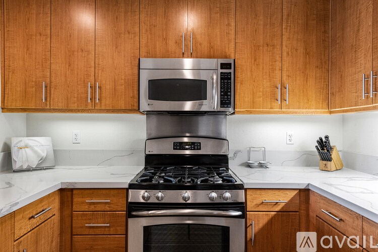 A kitchen with wooden cabinets and a stainless steel oven.
