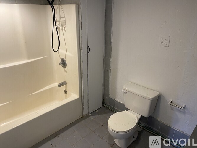 A white toilet in a bathroom with a white tub and shower.
