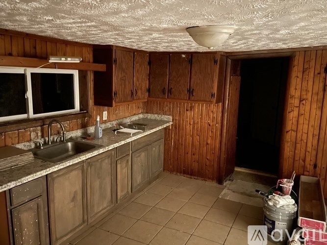 A kitchen with wooden cabinets and a sink.