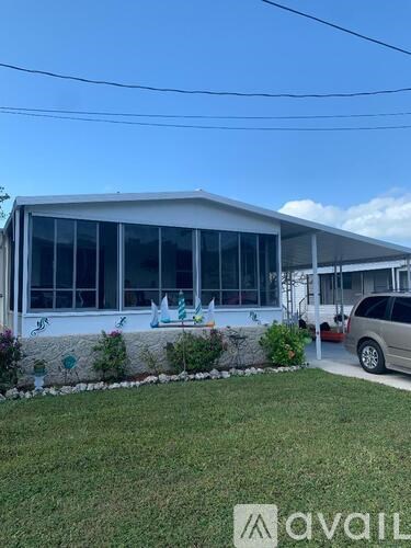 A white house with a car parked in front.