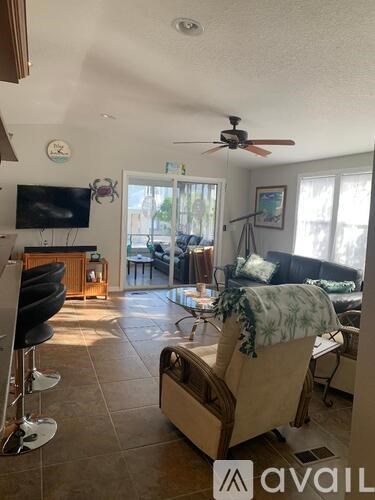 A living room with a couch, chair, and television.