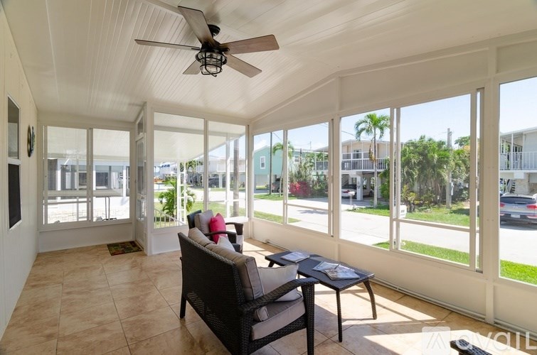 A sunny patio with a chair and table.