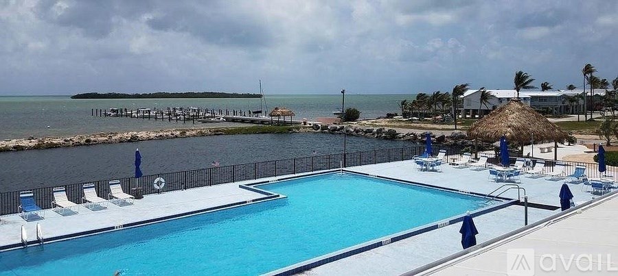 A large outdoor swimming pool with a view of the ocean.