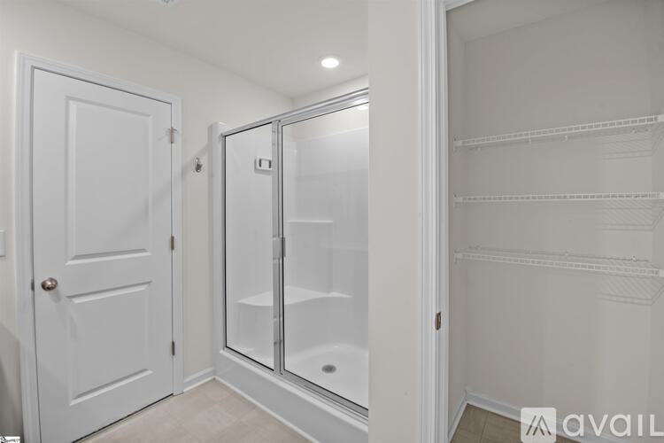 A white door is on the left and a white closet with shelves is on the right.