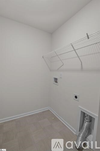 A room with a white wall and a pipe on the floor.