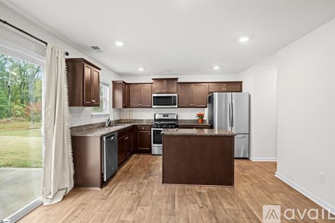 A kitchen with brown cabinets and a wooden island.