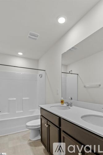 A bathroom with a toilet, sink, and mirror.