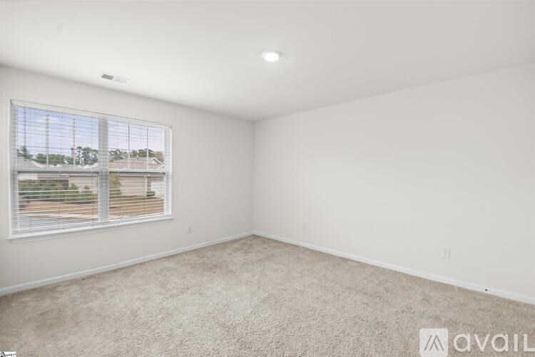 A room with a window overlooking a parking lot.