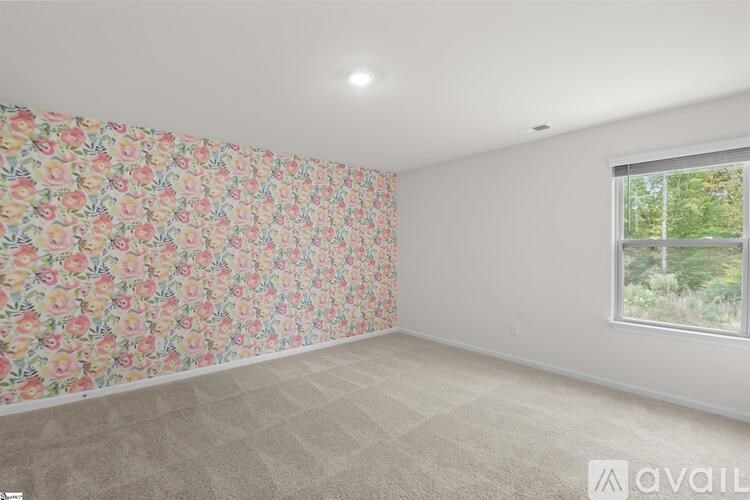 A room with floral wallpaper and a window showing greenery outside.