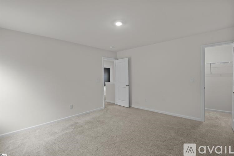 A room with a carpeted floor and a door leading to another room.