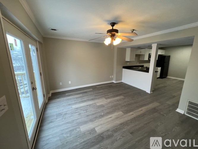 A room with a ceiling fan and wooden flooring.