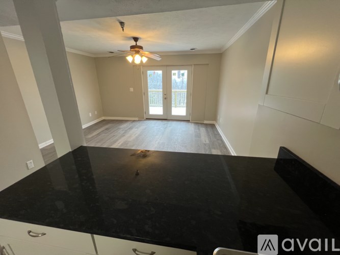 A spacious room with a black countertop and a ceiling fan.