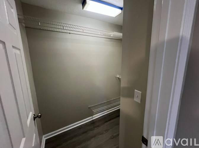 A small, empty room with a white door and a light on.