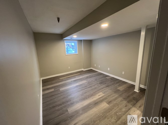 A room with wooden flooring and a window.